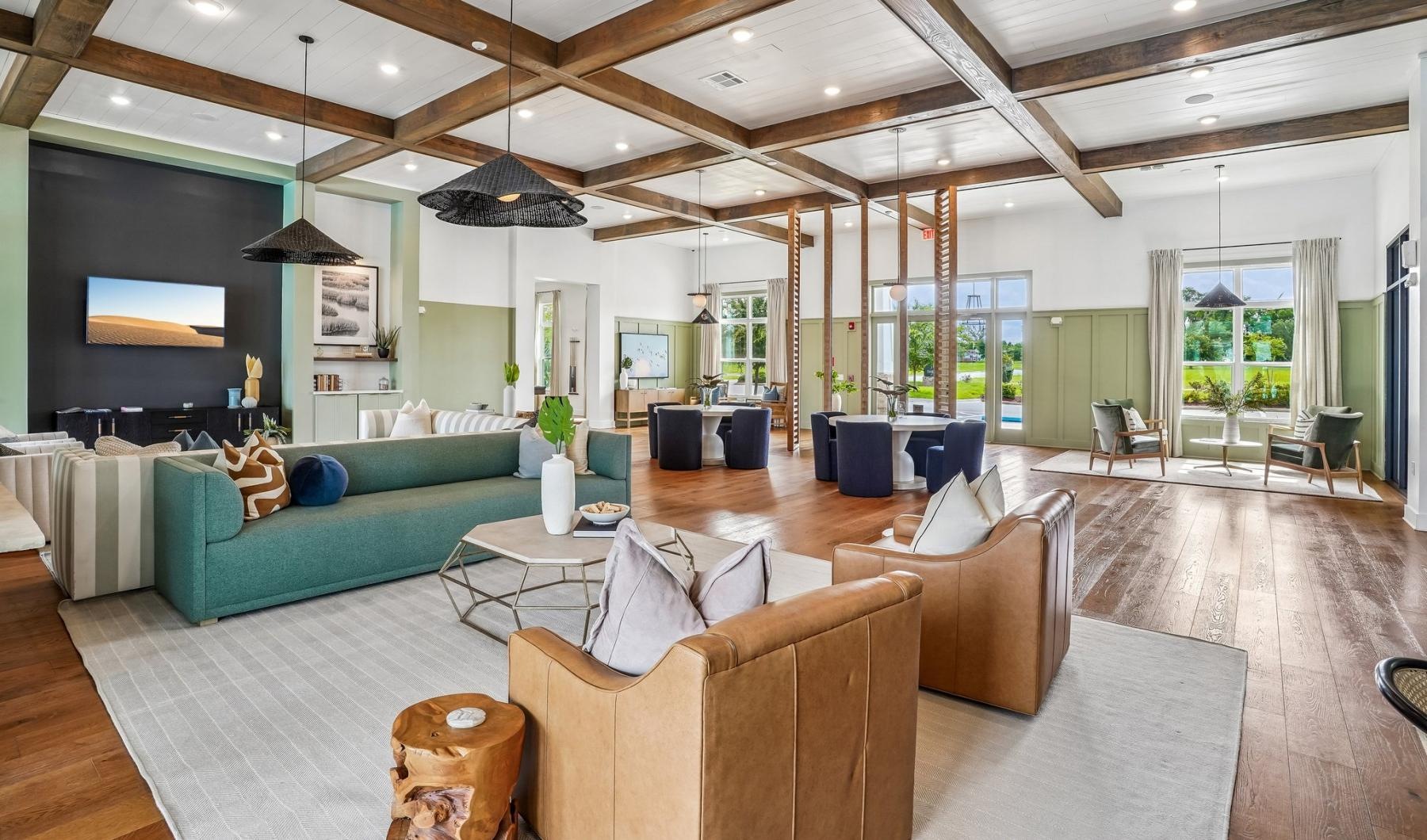 a clubroom with a tv, tables and couches
